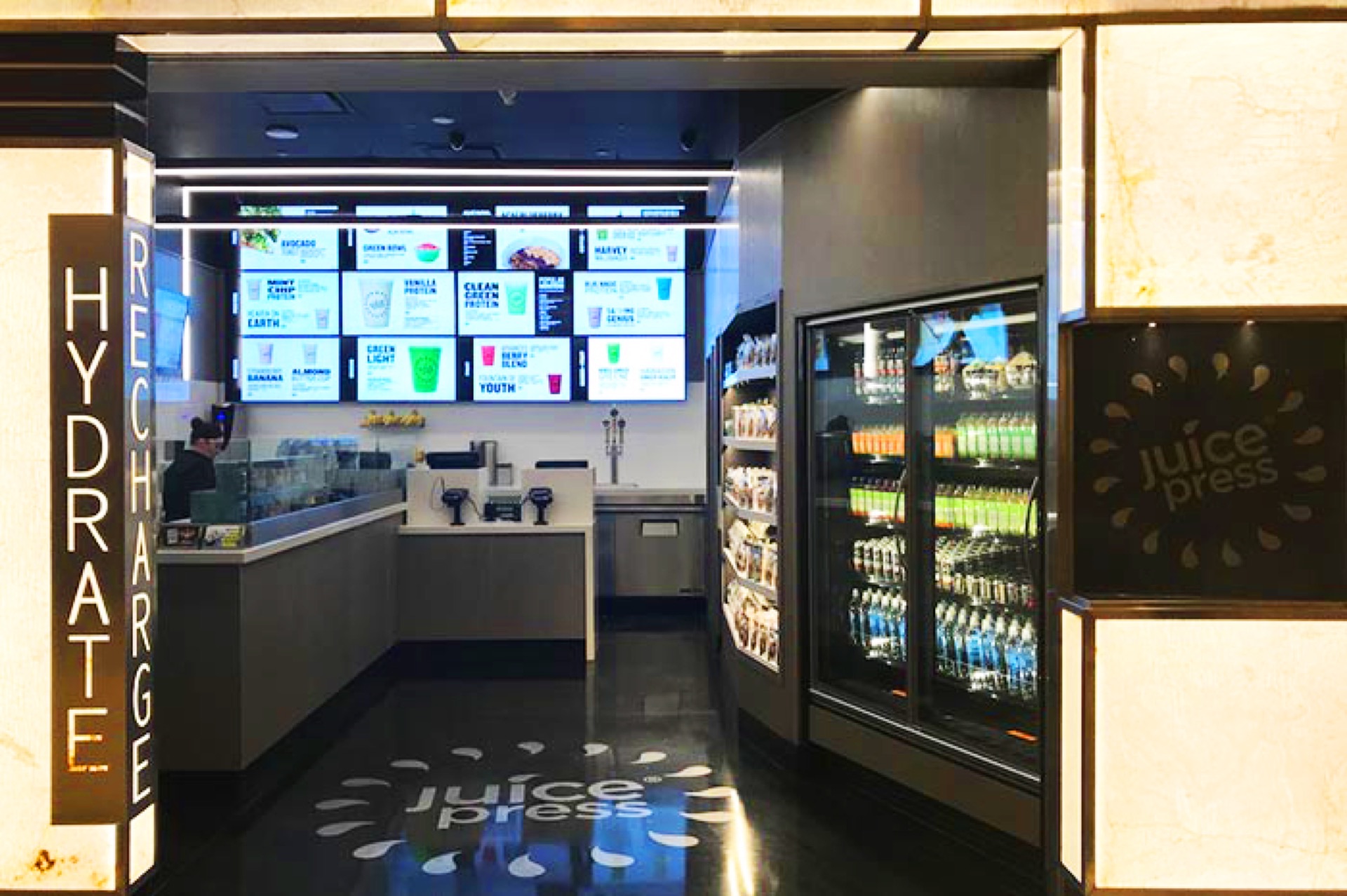 Juice bar with large digital menu wall and branded floor